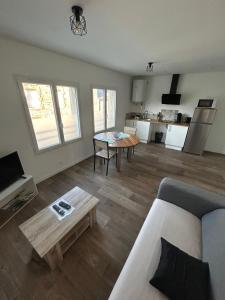 a living room with a couch and a table at Appartement T2 Saint Malo, Dinard, Dinan et Dol in Miniac-Morvan