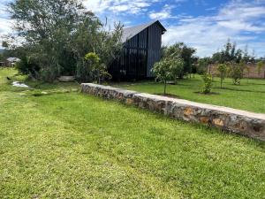 a stone retaining wall in a yard with a barn at Twenty ritz cottage in Migori