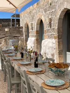 un lungo tavolo con piatti di cibo sopra di Masseria Specula a San Pietro in Bevagna
