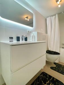 a white bathroom with a sink and a toilet at One Lux Stay Studio Basement near Antwerp Central in Antwerp