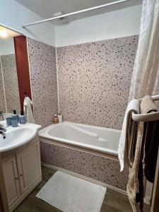 a bathroom with a bath tub and a sink at Au cœur des vignes - Piscine Sauna & Climatisation in Levernois +16 photos
