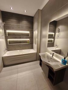 a bathroom with a tub and a sink and a bath tub at Comfort Plaza Andalus in New cairo