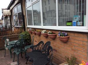 un patio con sillas, mesas y macetas en Brene Hotel, en Blackpool