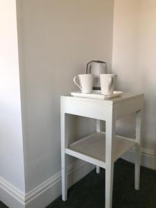 a white table with two cups on top of it at Ryedale House in Sleights