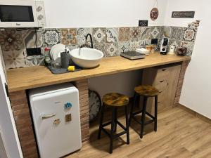 a kitchen with a counter with a sink and a refrigerator at Habitació amb encant a Blanes in Blanes