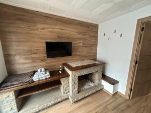 a living room with a stone fireplace with a flat screen tv at Habitació amb encant a Blanes in Blanes