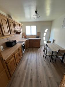 a kitchen with wooden cabinets and a table with chairs at La maison des amis in Beauvais