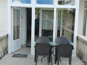 a patio with a table and chairs and a glass door at AK apartman in Sutomore +28 photos