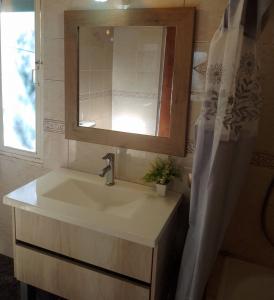 a bathroom with a sink and a mirror at Casa del Bosque Sierra de los Padres in Sierra de los Padres