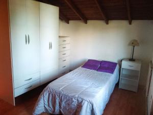 a bedroom with a bed and a dresser at Casa del Bosque Sierra de los Padres in Sierra de los Padres
