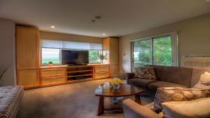 a living room with a couch and a tv at Spacious 2BR, 3BA Vermont Condo with EV Station, Ski Rental Deals & Summer Pool in Killington