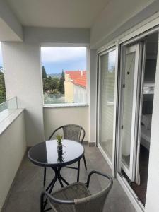 a small balcony with a table and chairs and a window at Luxuriöse Residenz mit mehreren Balkonen in Biograd na Moru