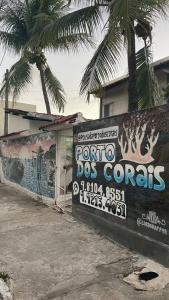 a sign for a porto dog corns on a wall at Pousada Porto dos Corais in Porto De Galinhas