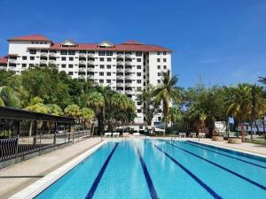a large swimming pool in front of a hotel at Sweet home2- 2 BR GlorybeachresortWiFiNetflixFreeparking in Port Dickson