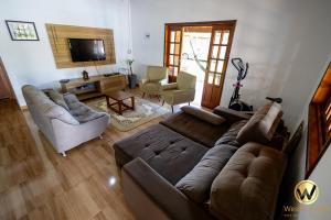 a living room with a couch and a tv at Chácara Sol Nascente in Ibiúna