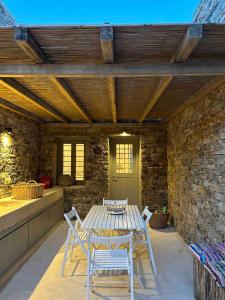 a table and chairs on a patio with a brick wall at VILLA CHRISTINA-Soros beach, Antiparos in Andiparos +44 photos