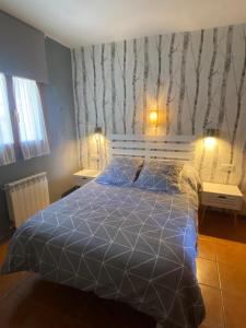 a bedroom with a bed with a blue comforter at El capricho de Trevélez in Trevélez