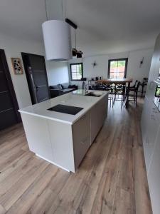 a kitchen with a white counter top and a wooden floor at la Maison d'à côté Chambre 3 in Cuise-la-Motte