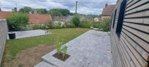 a backyard with a patio and a yard with chairs and a yard at la Maison d'à côté Chambre 3 in Cuise-la-Motte +1 photo