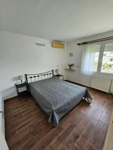 a bedroom with a bed and a wooden floor at Sunset on the Beach Apartment in Eretria