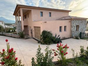 a house with a driveway in front of it at L'Osari, villa vue mer, accès plage à pied, golf, jardin clos pour enfants in Palasca