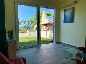 a room with a sliding glass door with a glass table at Jolie apartment-Panorama view in Porto Rafti