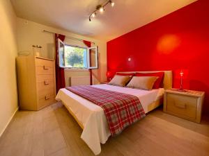 a red bedroom with a bed and a window at Jolie apartment-Panorama view in Porto Rafti