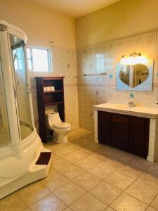 a bathroom with a toilet and a sink and a shower at Vacation Home in San Ignacio, Belize - Sleeps 10 in San Ignacio