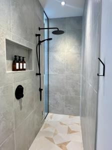una ducha con puerta de cristal en un baño en Le Föss, Fleuve, Sauna & Spa, en Petite-Rivière-Saint-François