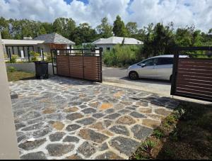 a driveway with a gate and a car parked at Naturo Villa 16 in Poste Lafayette