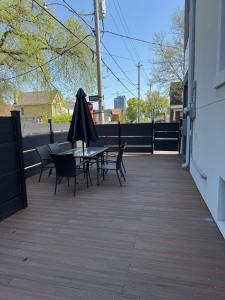 a patio with tables and chairs and an umbrella at Adorable Modern Master Bedroom near Colleges and K-town in Toronto