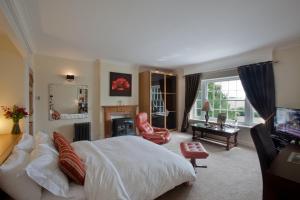 a bedroom with a large bed and a living room at Sturmer Hall Hotel and Conference Centre in Haverhill