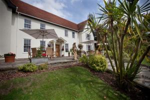 a house with a patio and an umbrella at Sturmer Hall Hotel and Conference Centre in Haverhill