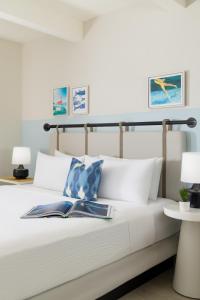 a bedroom with a white bed with two books on it at Blue Flamingo Resort Key West in Key West