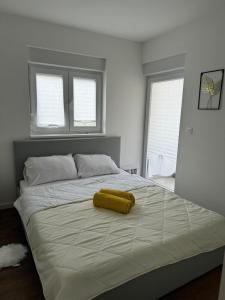 a bedroom with a large bed with a yellow blanket on it at Inviting and bright 90 m2 residence with 4 balconies in Biograd na Moru