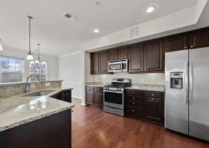 a kitchen with stainless steel appliances and wooden cabinets at Premium Bedroom & Private Bathroom Long or Short Term 1 in Dale City +7 photos
