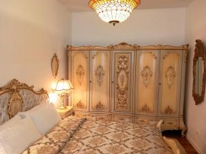 een slaapkamer met een groot bed en een kroonluchter bij Old Town Gem in Naujoji Akmenė