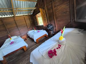a room with two beds and flowers on them at Cabañas Iracas del Mar in Nuquí +159 photos