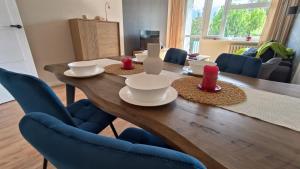 a dining room table with blue chairs around it at Millenium Park Apartment 2-pokojowy in Gdańsk