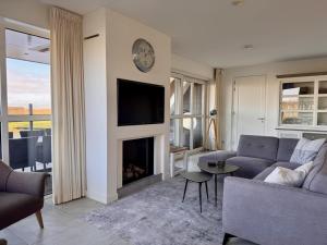 un soggiorno con divano e camino di Relaxing Villa with Fireplace a Delfstrahuizen