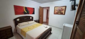 um quarto com uma cama e uma pintura na parede em Hotel Makai SAS em Ríohacha