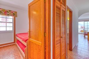 a room with a wooden closet with a red bed at Apartamento Roque Horizonte in Puerto Naos