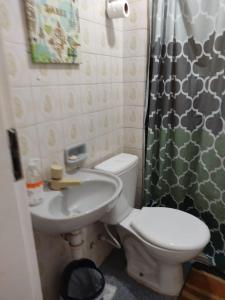 a bathroom with a toilet and a sink and a shower curtain at Hostel Farol da Barra in Salvador +3 photos