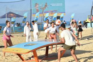 a group of people playing volley ball on the beach at الحي اللاتيني العلمين الجديده علي اللاجون والابراج Latini in El Alamein
