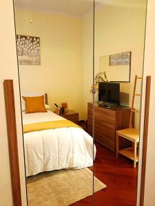 a bedroom with a bed and a desk and a television at Il Cedro Charme & Suite in Valenzano +35 photos