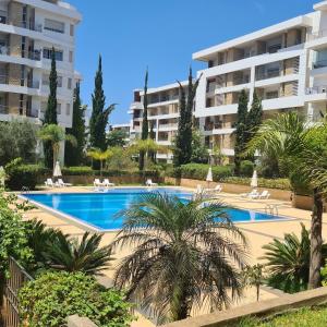 a swimming pool in front of a large apartment building at Luxurious entire apartment, 169 m2, secure, swimming pool in Rabat