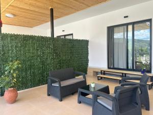 a patio with chairs and tables and a green hedge at Sofia Central House Berat in Berat