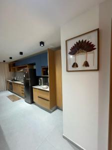 a kitchen with a refrigerator and a picture on the wall at Casa Aroeira Milagres in São Miguel dos Milagres +14 photos