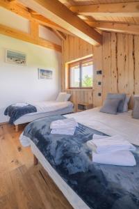 a bedroom with two beds in a wooden cabin at Au Soleil Couchant in Foncine-le-Haut