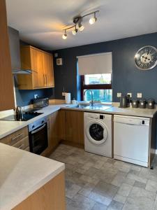eine Küche mit einer Waschmaschine und einem Geschirrspüler in der Unterkunft Forbela House in Fort William